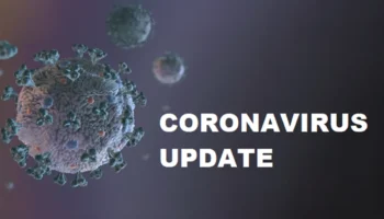 A 3D Illustration Of Coronavirus Particles On A Dark Background, With The Text CORONAVIRUS UPDATE Written In Bold White Letters On The Right Side Of The Image.