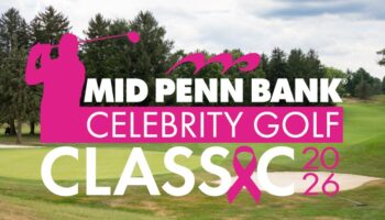 A Golf Course With Trees In The Background Features A Bold Pink And White Logo Reading “Mid Penn Bank Celebrity Golf Classic 2026” With A Pink Ribbon Replacing The “A” In “Classic.”.